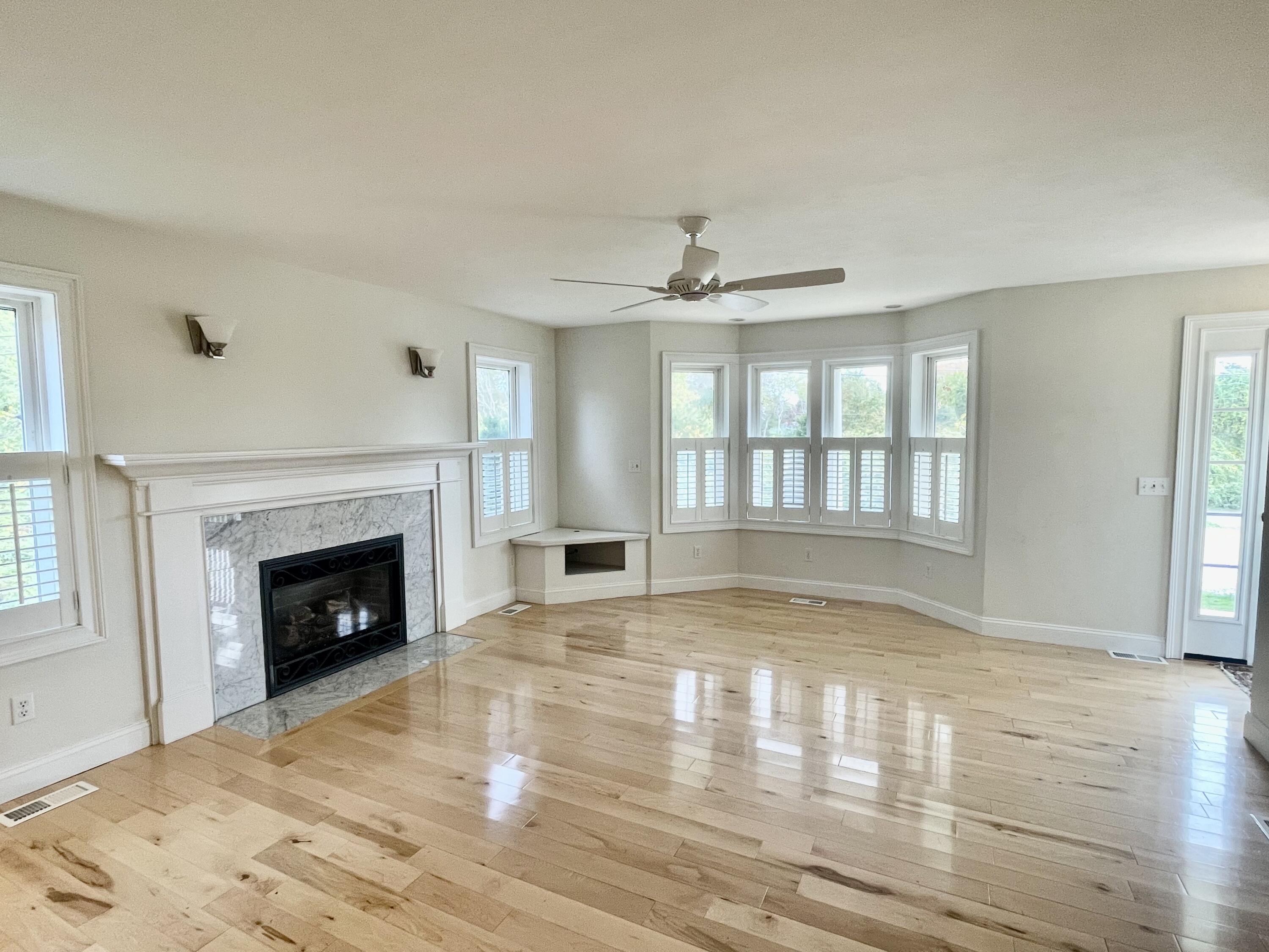 215 Harbor Point Road Barnstable, MA 02675 - Photo 3 of 10 a view of empty room with wooden floor and fireplace