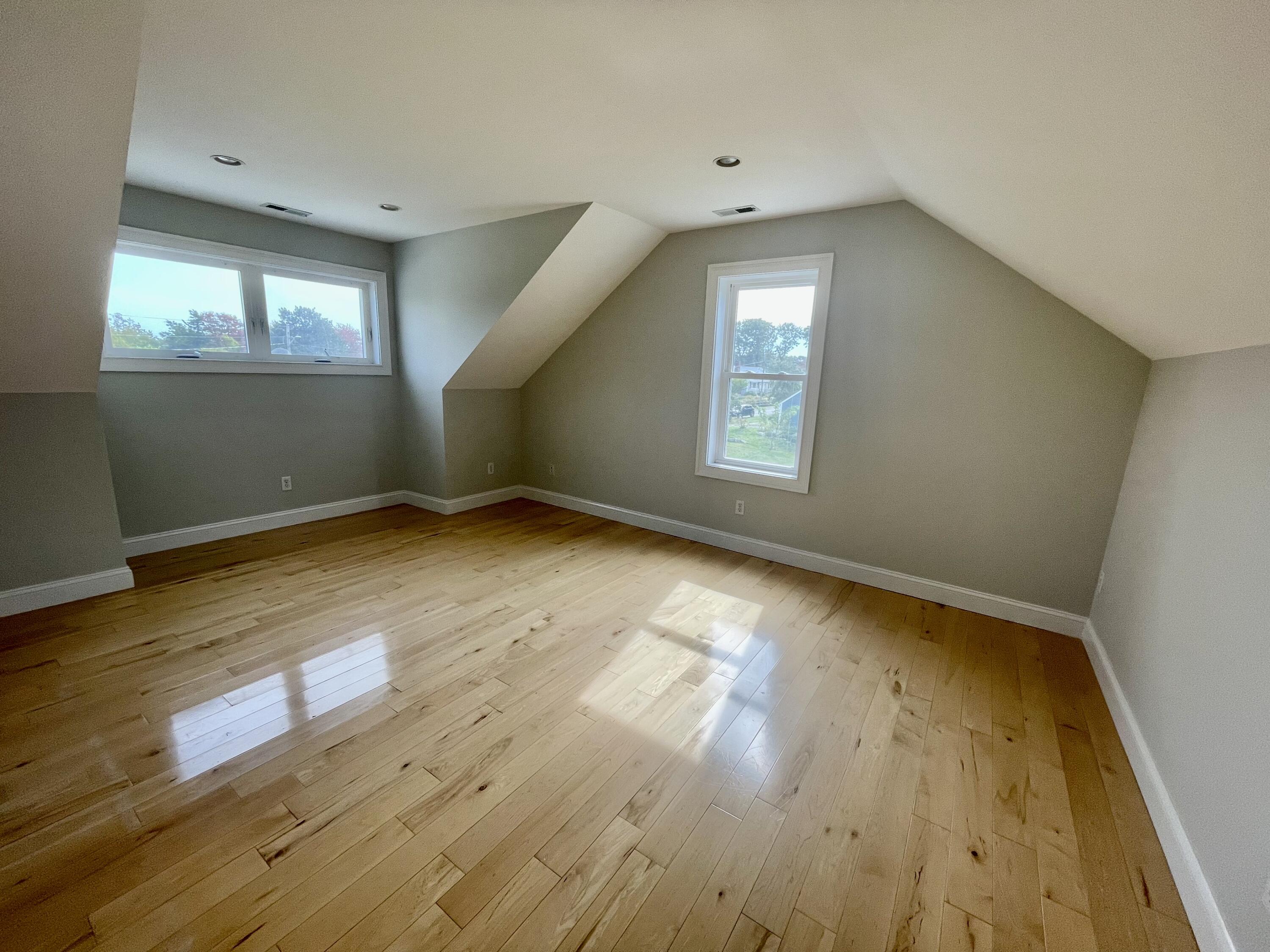 215 Harbor Point Road Barnstable, MA 02675 - Photo 8 of 10 an empty room with wooden floor and windows