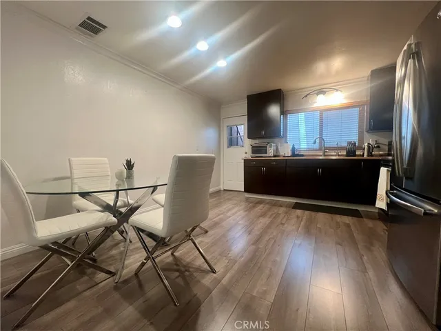 a view of a dining room with furniture a chandelier and wooden floor