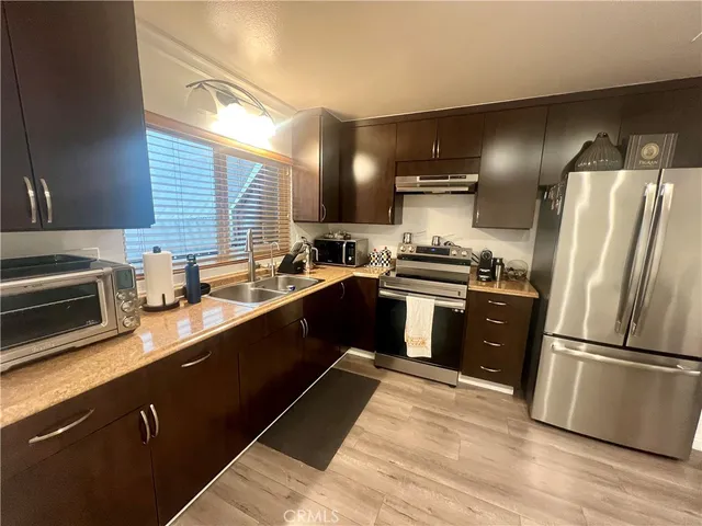 a kitchen with granite countertop stainless steel appliances and wooden cabinets