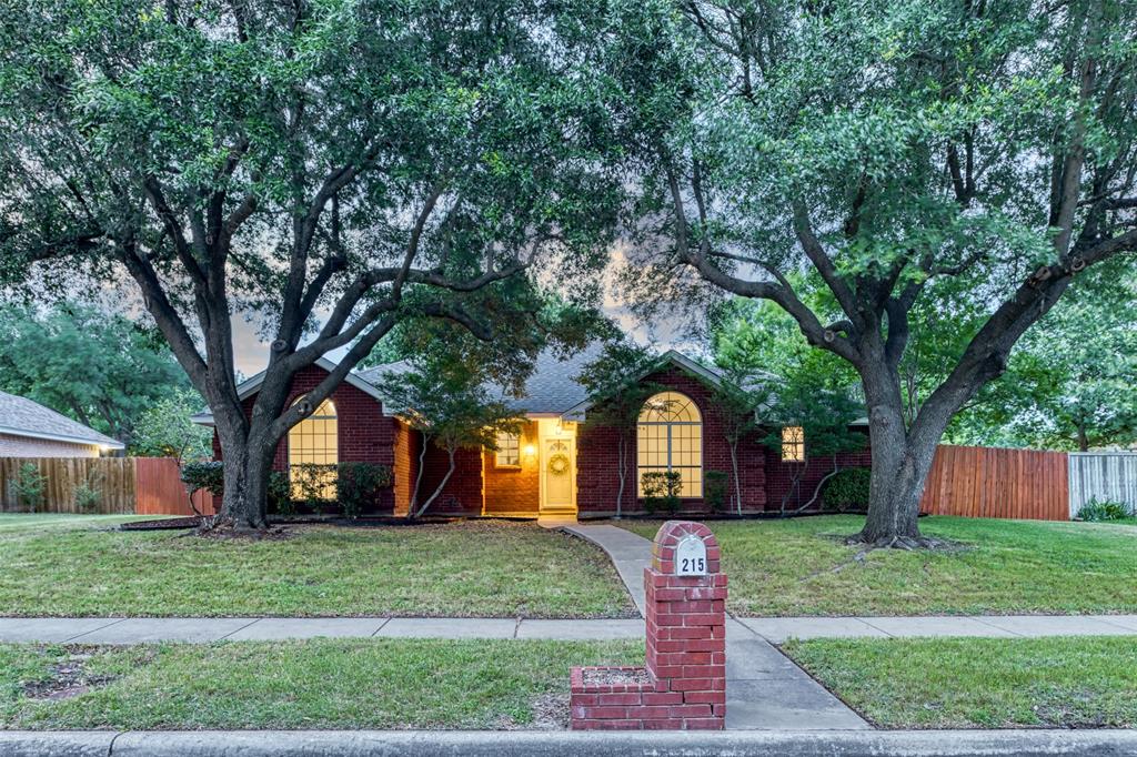 215 Barbara Way Red Oak, TX 75154 - Photo 1 of 36 Evening curb appeal showcases the home’s inviting presence, with mature trees, warm exterior lighting, and classic neighborhood character.
