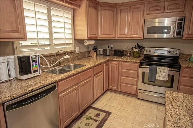 a kitchen with stainless steel appliances granite countertop a sink stove and microwave