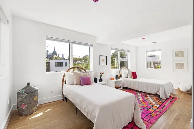 a bedroom with two beds and a large window