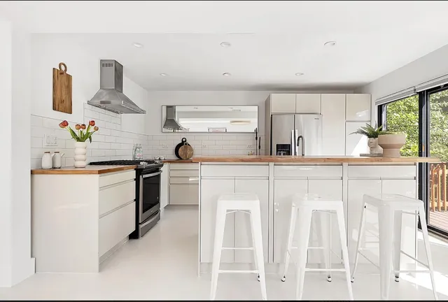 a kitchen with white cabinets and appliances