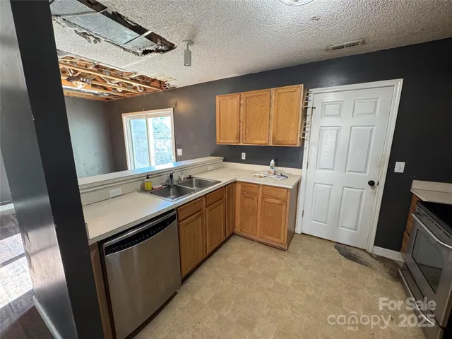 a view of an empty room with wooden floor fireplace and a window