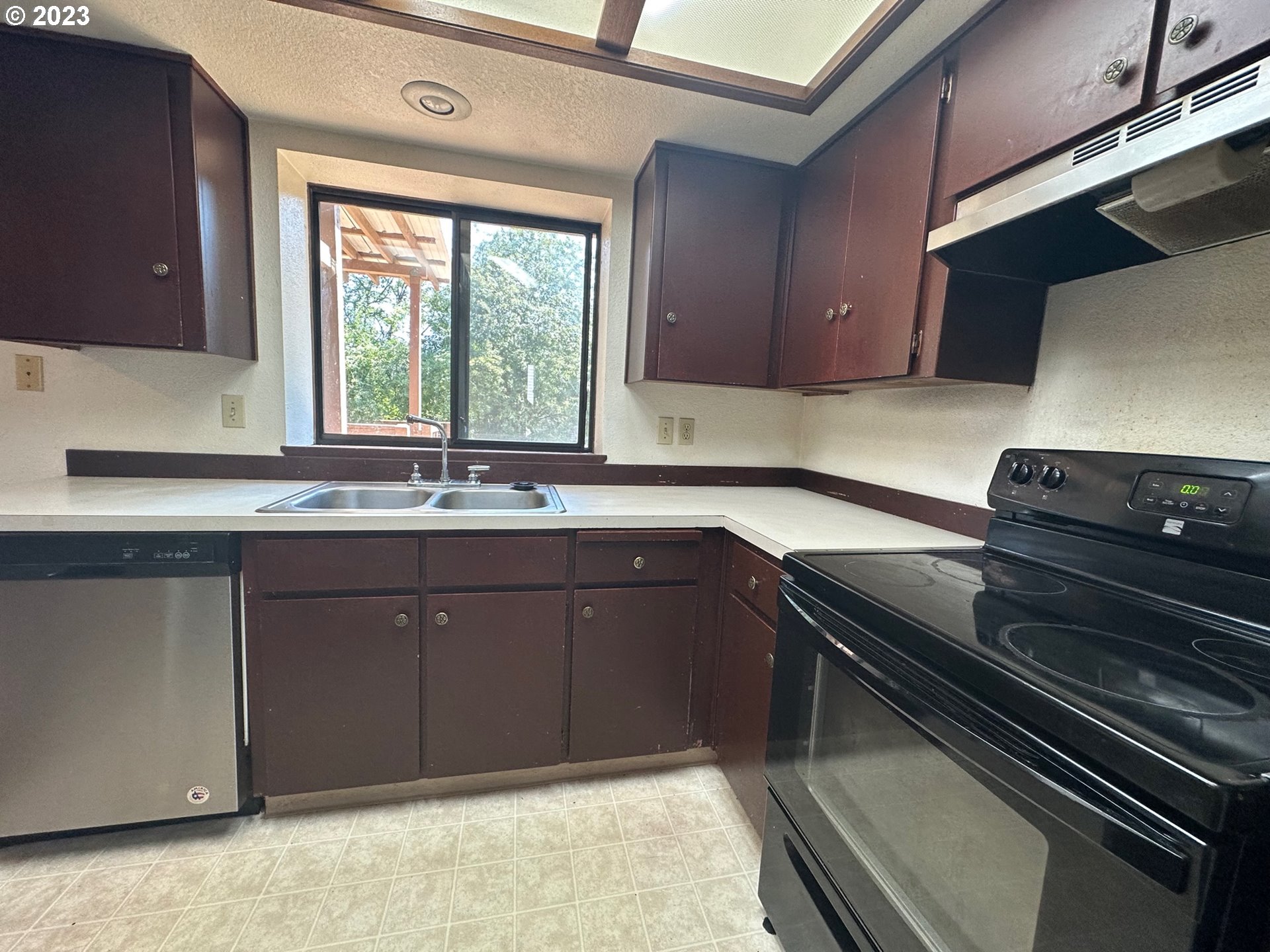 13922 Southeast Bush Street Portland, OR 97236 - Photo 11 of 29 a kitchen with a sink stove and cabinets
