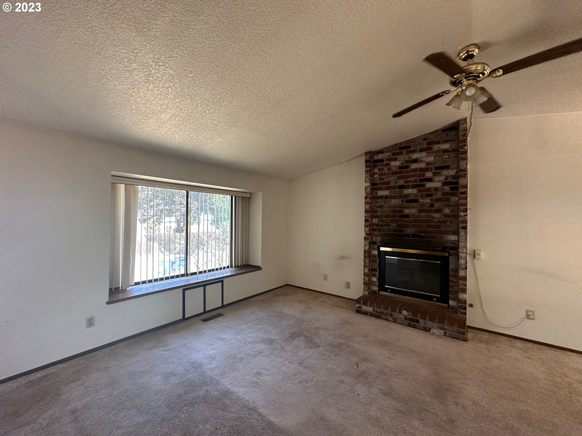 13922 Southeast Bush Street Portland, OR 97236 - Photo 6 of 29 an empty room with windows fireplace and fan