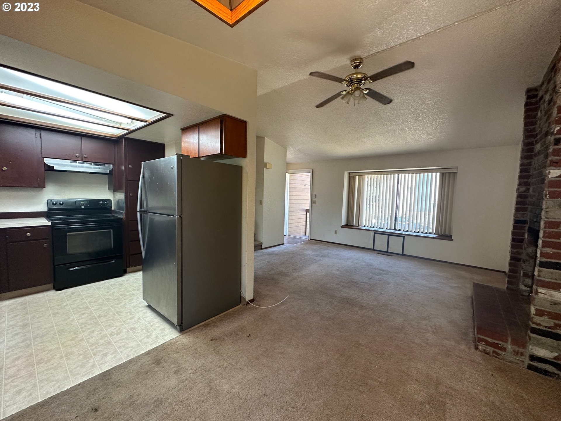 13922 Southeast Bush Street Portland, OR 97236 - Photo 9 of 29 a view of a kitchen with a refrigerator and a ceiling fan
