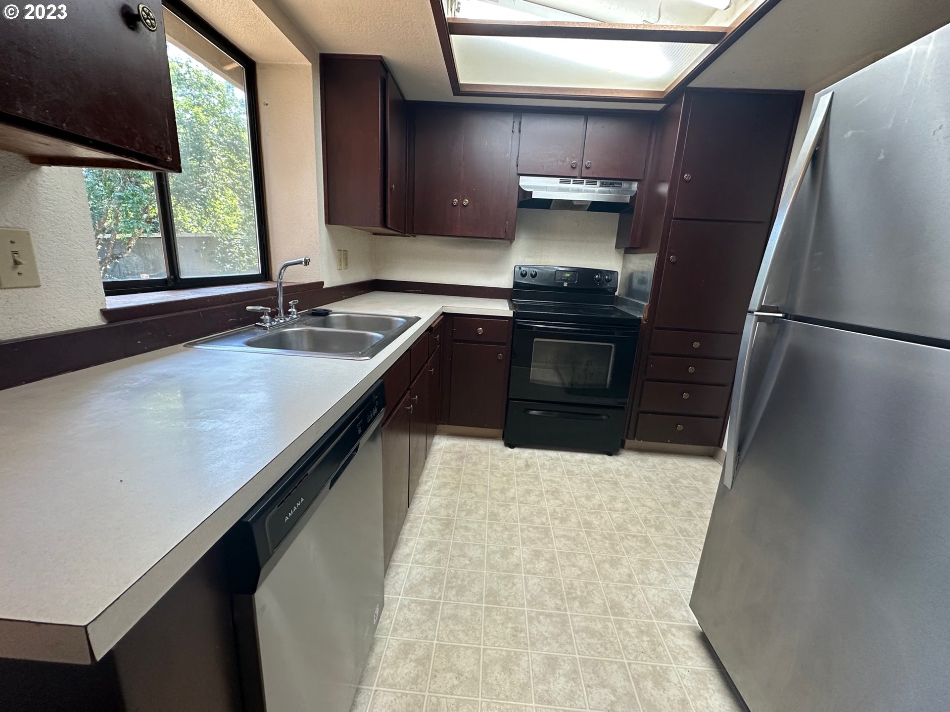 13922 Southeast Bush Street Portland, OR 97236 - Photo 10 of 29 a kitchen with granite countertop a refrigerator and a sink