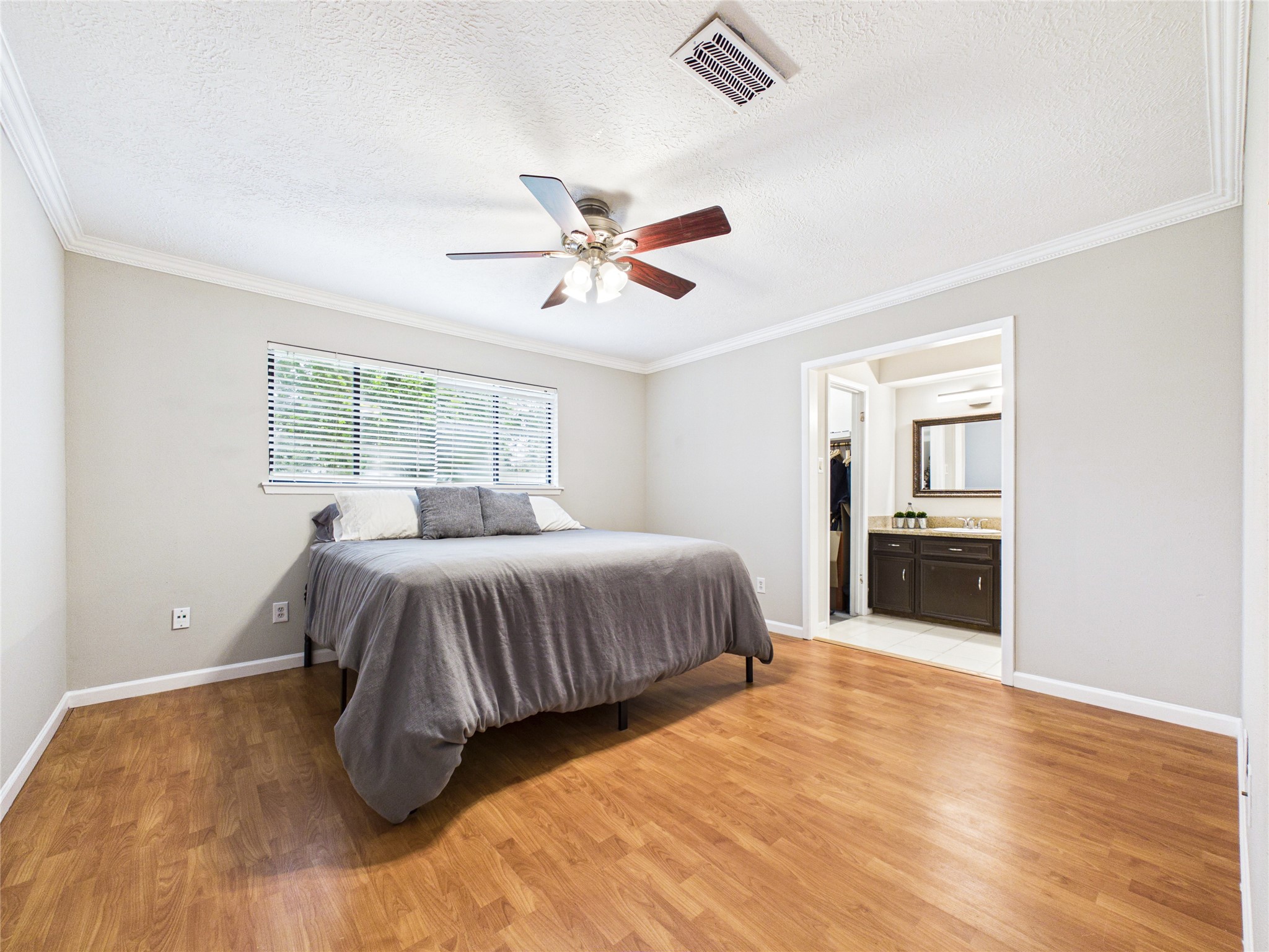 10306 Rustic Rock Road La Porte, TX 77571 - Photo 17 of 38 a spacious bedroom with a large bed a chandelier and windows