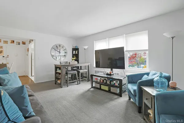 a living room with furniture a wall paintings and a window