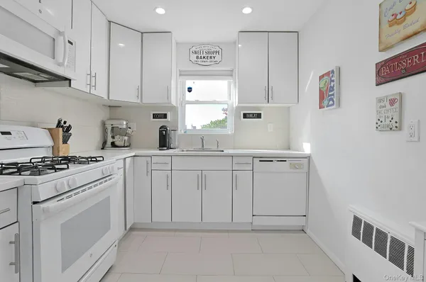 a kitchen with white cabinets and white appliances