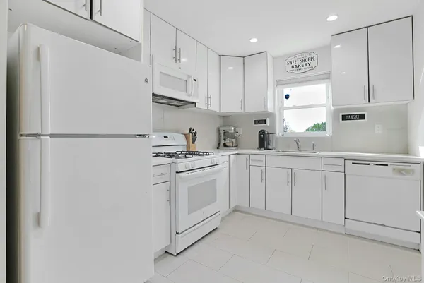 a kitchen with white cabinets and white appliances