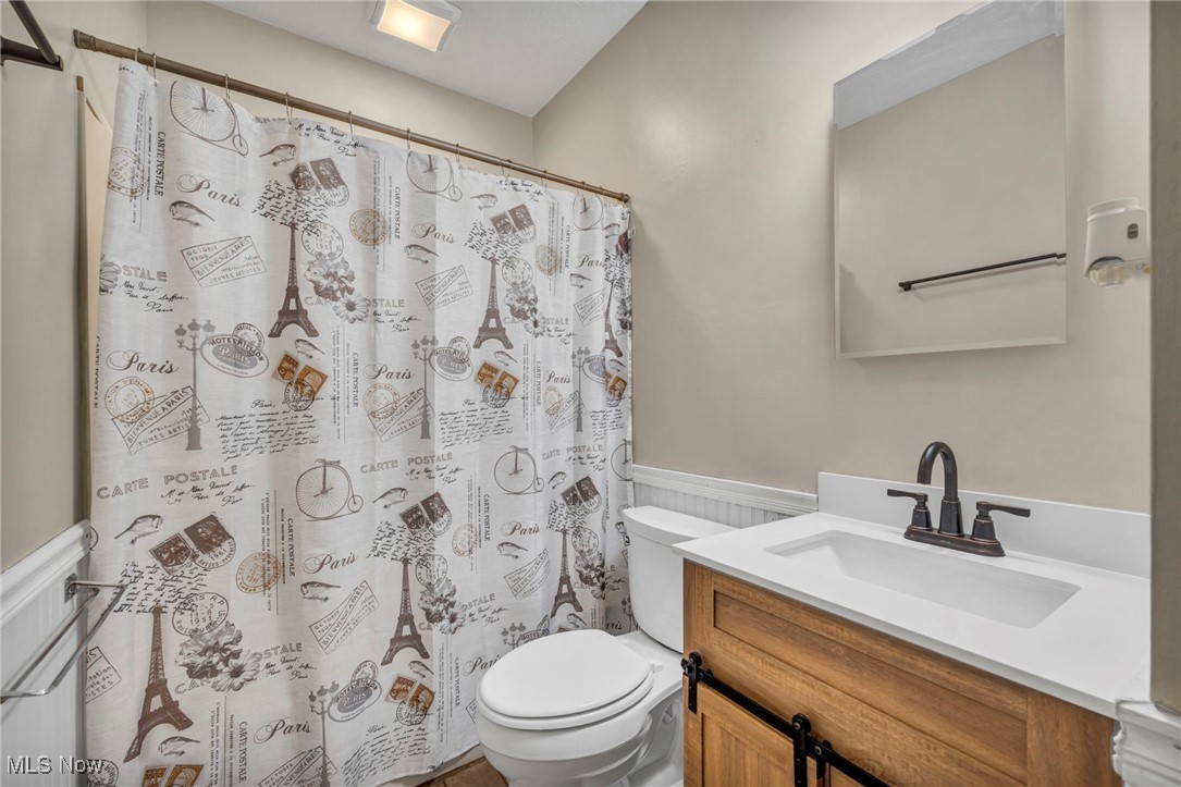 1425 Keefer Road Girard, OH 44420 - Photo 23 of 37 Bathroom with a wainscoted wall, vanity, and a shower with curtain