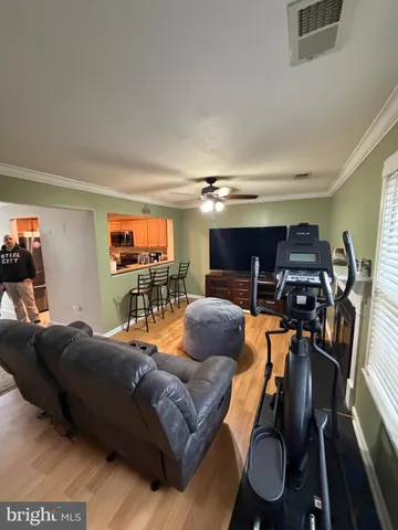 a living room with furniture a ceiling fan and a window