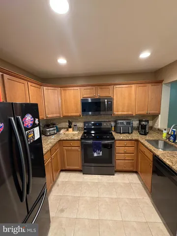 a kitchen with stainless steel appliances granite countertop a stove sink and cabinets