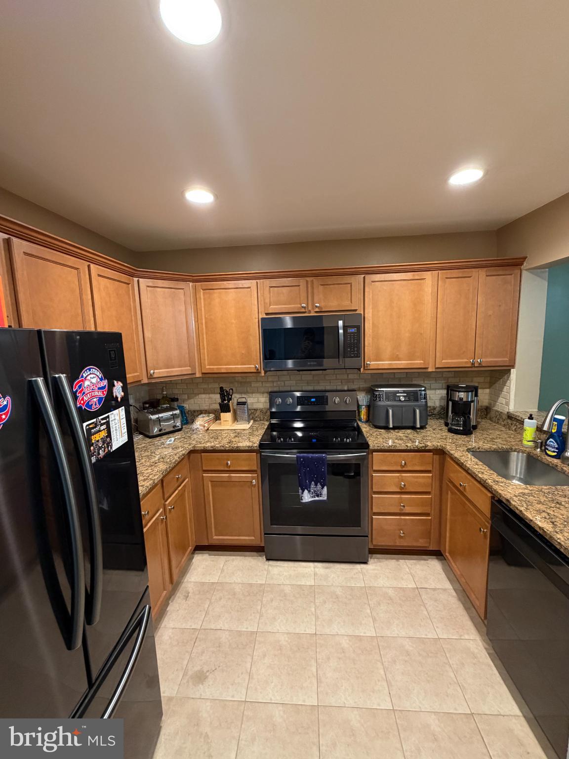6036 Old Landing Way Burke, VA 22015 - Photo 7 of 19 a kitchen with stainless steel appliances granite countertop a stove sink and cabinets