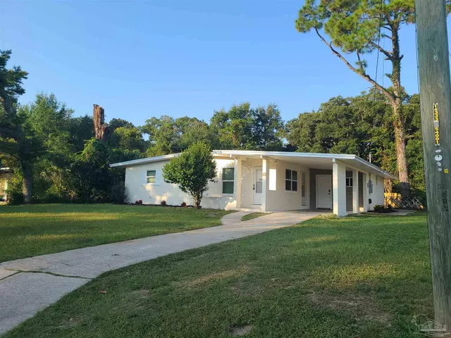 a front view of a house with a garden and trees