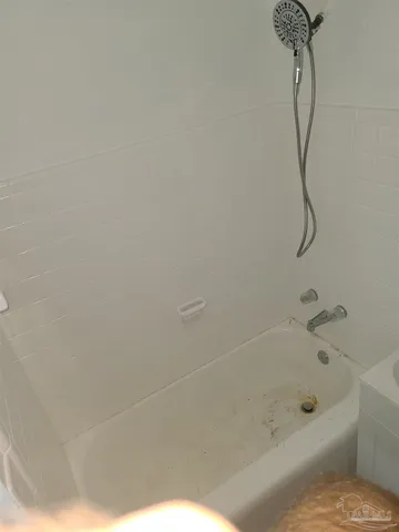 a bathroom with a bath tub with a shower
