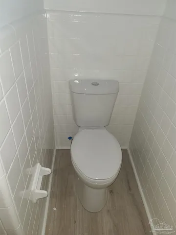 a white toilet sitting next to a shower