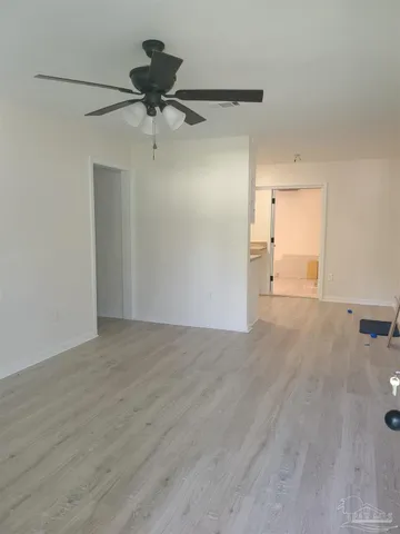 a view of a room with wooden floor and a ceiling fan