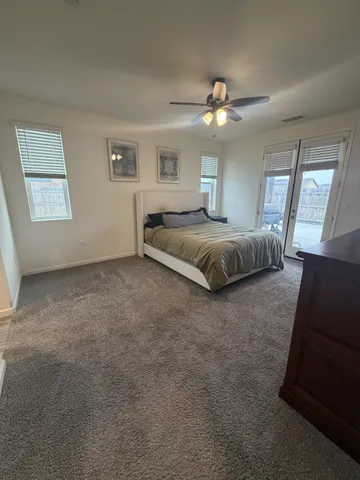 a spacious bedroom with a large bed chandelier and a window