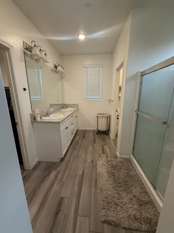 a bathroom with a sink a toilet a mirror and shower