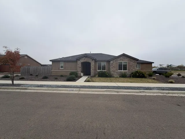 a front view of a house with a yard and parking space