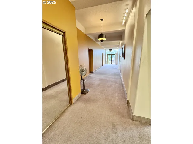 a view of a room with a large window and wooden floor