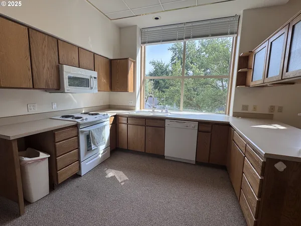 a kitchen with a sink stove top oven and cabinets