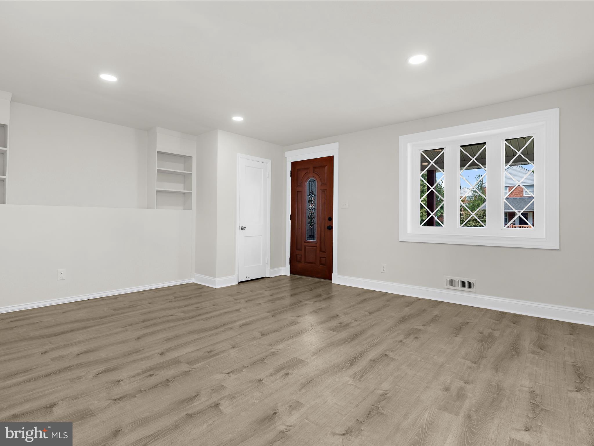 7821 Rockbourne Road Baltimore, MD 21222 - Photo 3 of 56 a view of an empty room with wooden floor and window