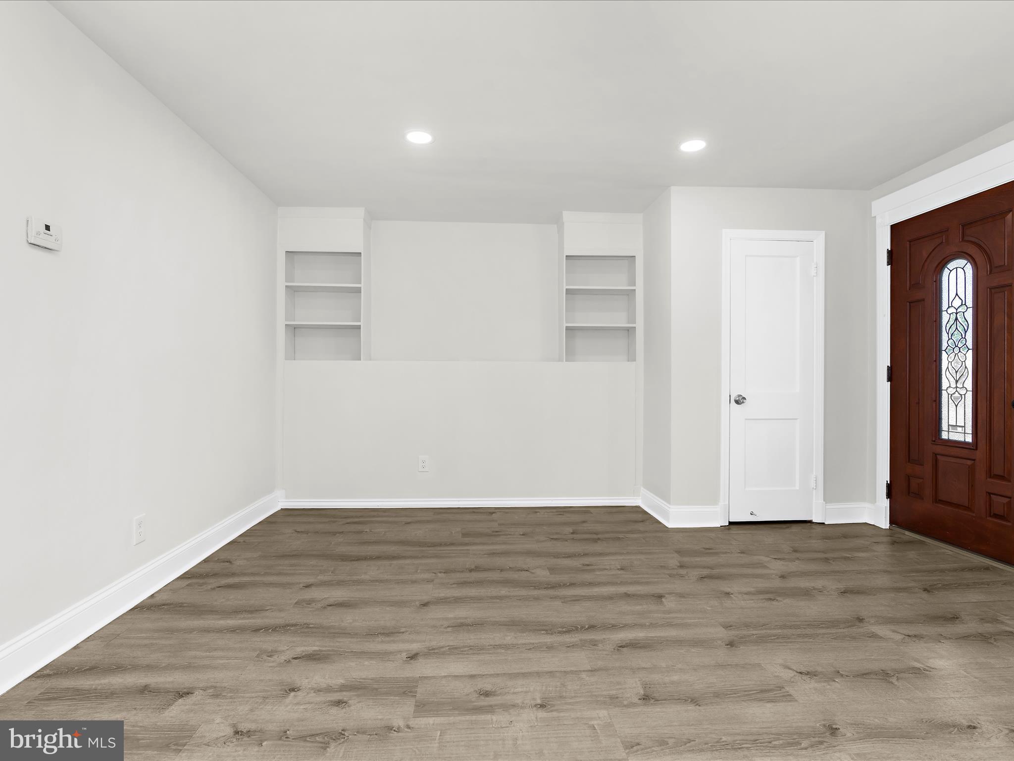 7821 Rockbourne Road Baltimore, MD 21222 - Photo 4 of 56 a view of an empty room with wooden floor and windows