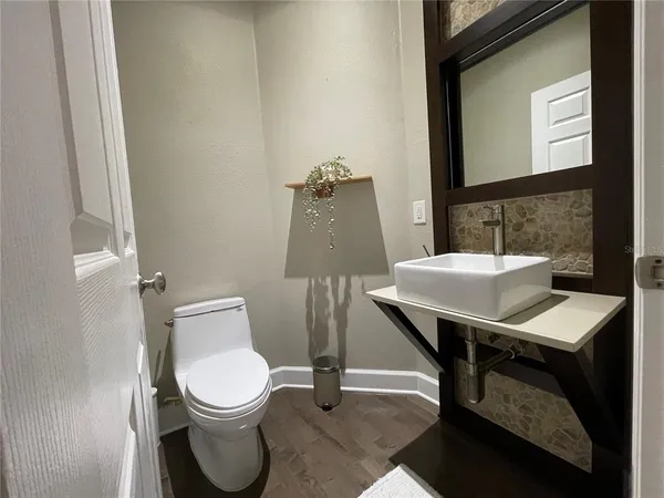 a bathroom with a toilet a sink and mirror