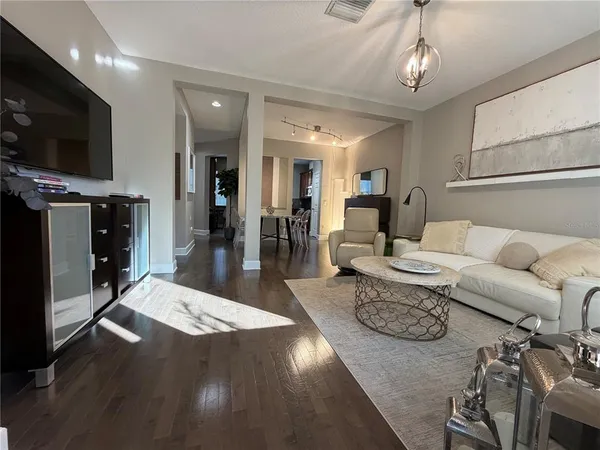 a living room with furniture and a wooden floor