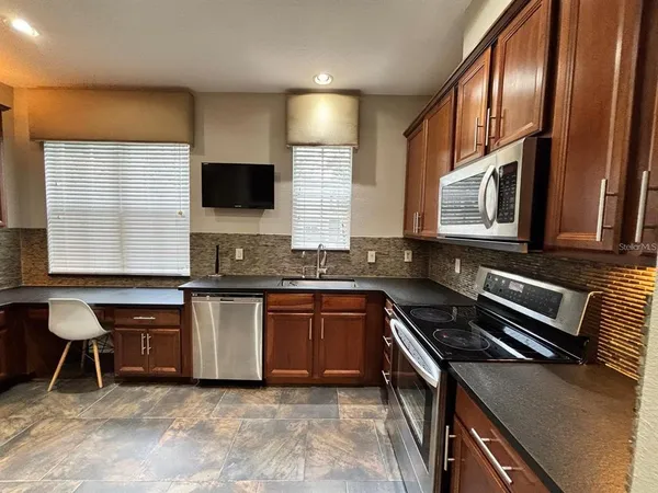 a kitchen with granite countertop a stove a sink and a microwave