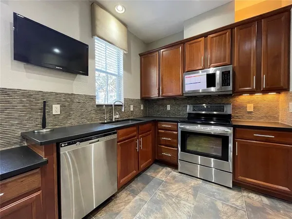 a kitchen with stainless steel appliances granite countertop a stove a sink and a microwave