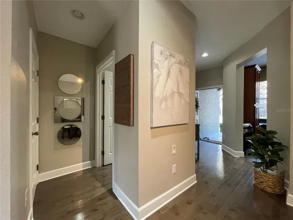a view of a hallway with wooden floor and a living room