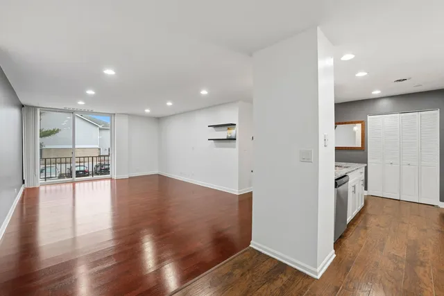 a view of empty room with wooden floor