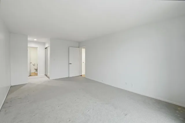 an empty room with furniture and a ceiling fan