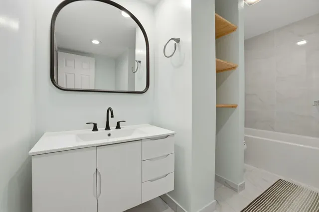 a white bath tub sitting next to a toilet