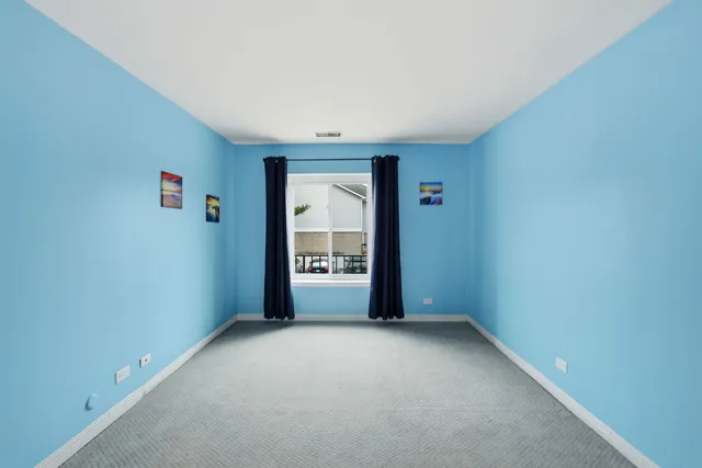 an empty room with closet and a window