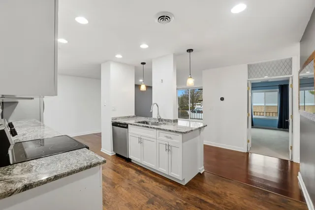 a kitchen with stainless steel appliances white cabinets granite counter tops and a stove