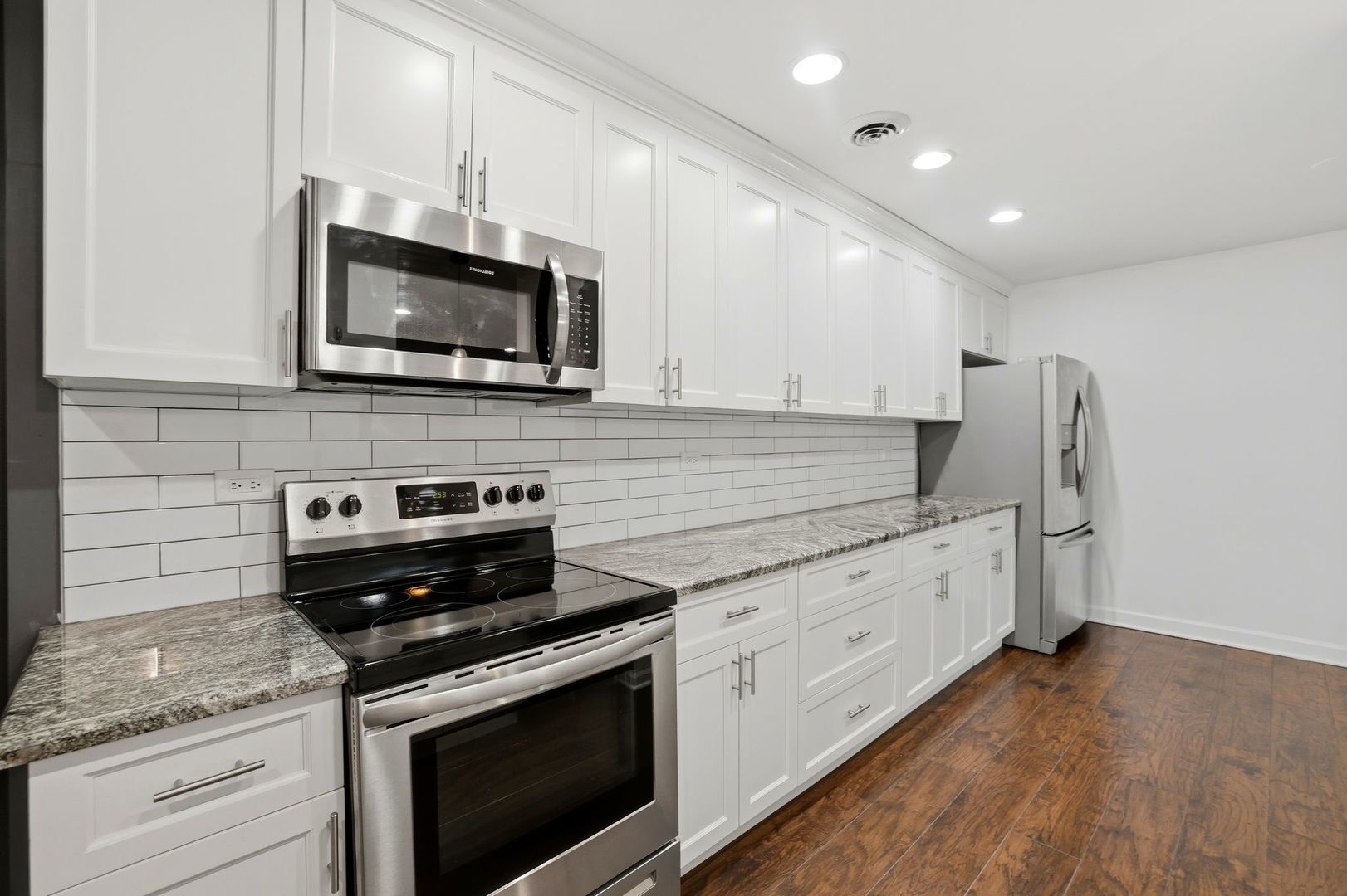 190 South Wood Dale Road, Unit 200 Wood Dale, IL 60191 - Photo 8 of 34 a kitchen with stainless steel appliances white cabinets granite counter tops and a stove