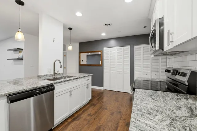 a kitchen with stainless steel appliances granite countertop a sink stove and refrigerator