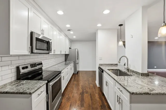 a kitchen with granite countertop a stove and a sink