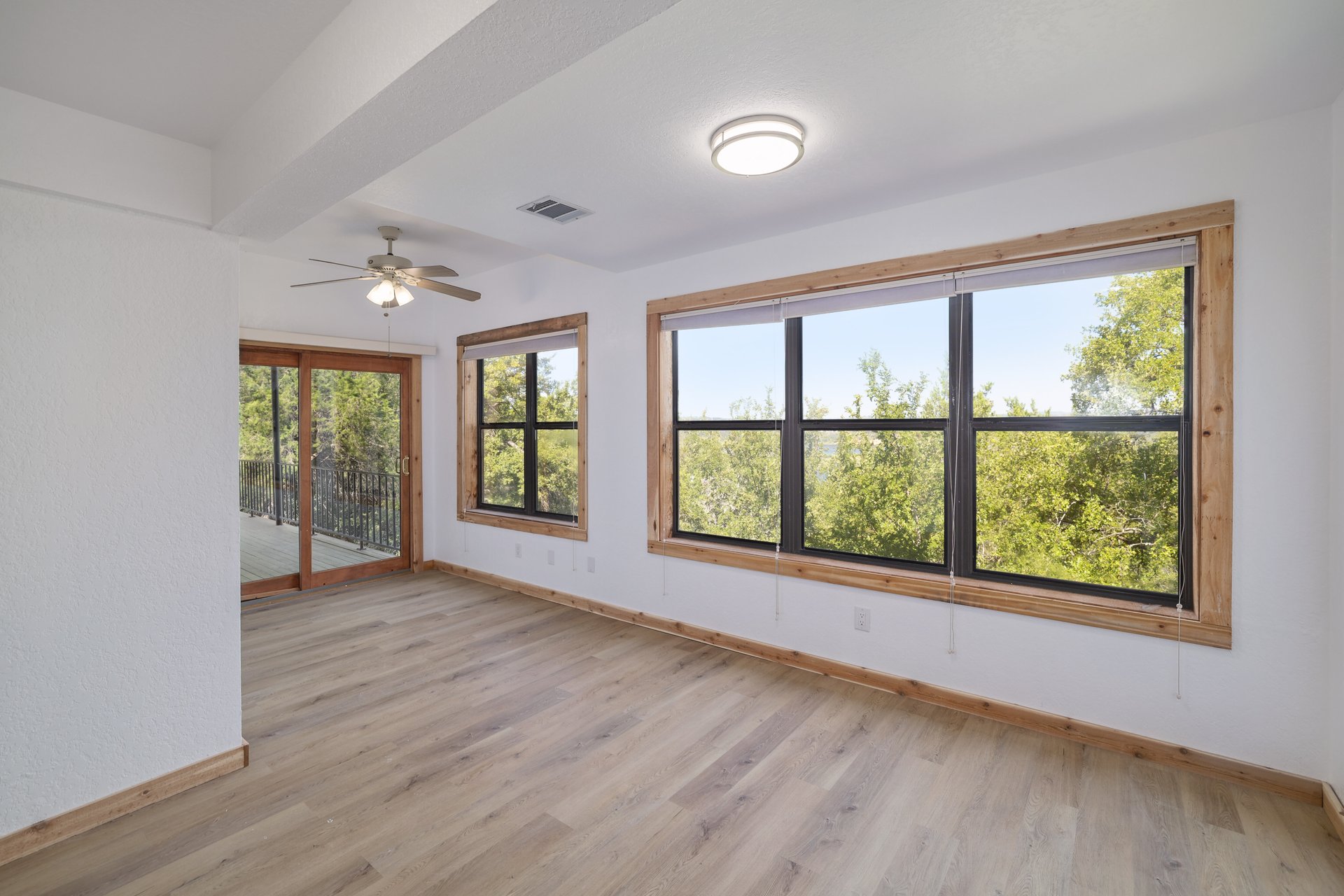 313 Kendall Road Spicewood, TX 78669 - Photo 19 of 34 Unfurnished room featuring light wood-style flooring, healthy amount of natural light, beam ceiling, and a ceiling fan