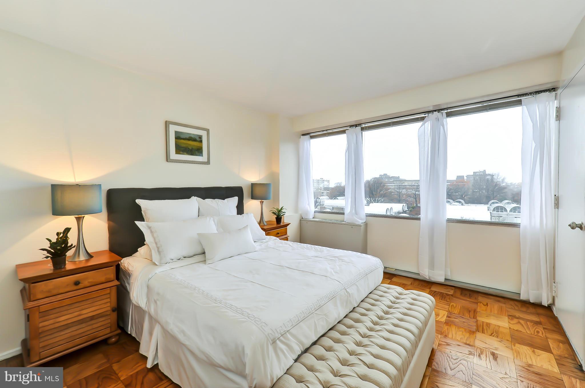 1301 Delaware Avenue Southwest, Unit N504 Washington, DC 20024 - Photo 6 of 29 a bed room with a bed and a night stand