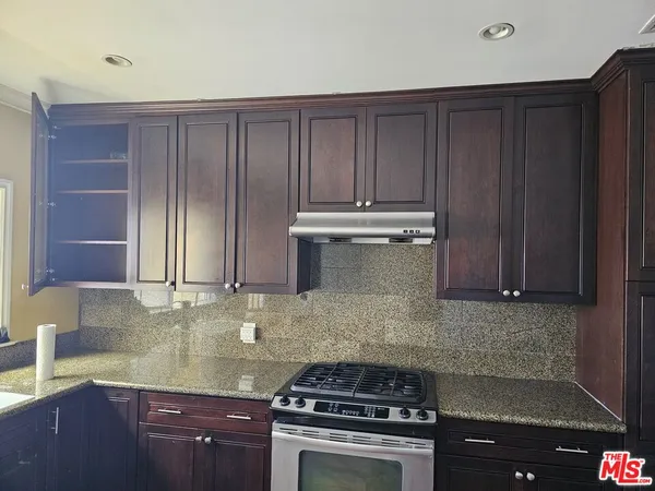 a kitchen with wooden cabinets and a stove top oven