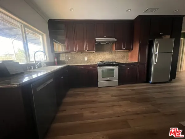 a kitchen with stainless steel appliances granite countertop a sink stove and refrigerator