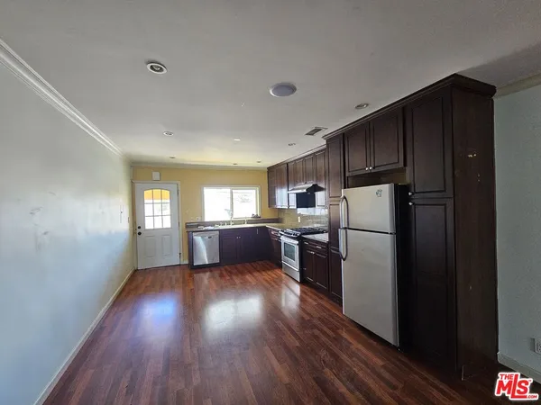 a kitchen with sink a refrigerator and wooden floor